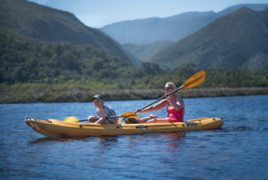 Mother and son kayaking in South Africa, blue sky