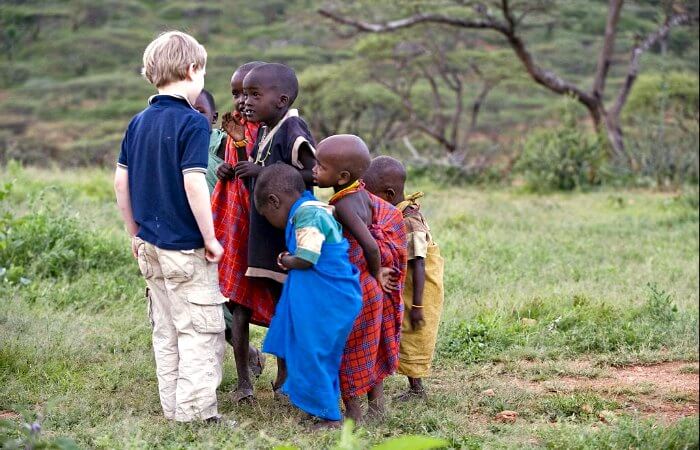 Local kids meeting young tourist on a Kenya family safari
