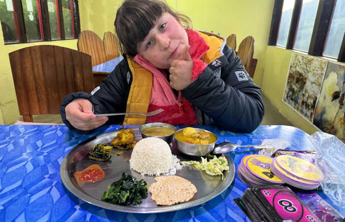 Child trying tradition food in Nepal on family trip