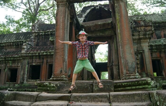Cambodia itineraries - young boy jumping in front of temple