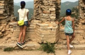 China family holidays - two girls look out from the Great Wall of China