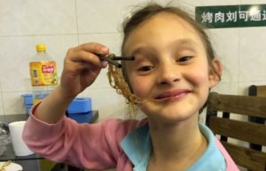 Young girl eating noodles and smiling - China customer reviews