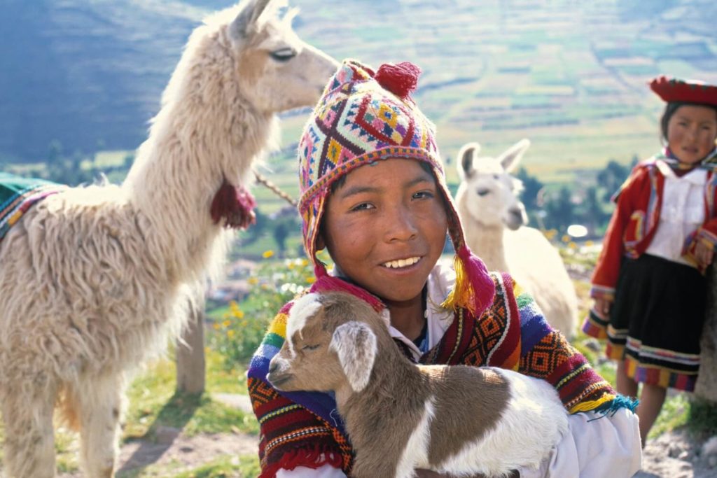 Peru family holidays - young shepherd with a baby goat
