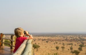 Young boy looks across the plains in the Serengeti on a Tanzania family safari