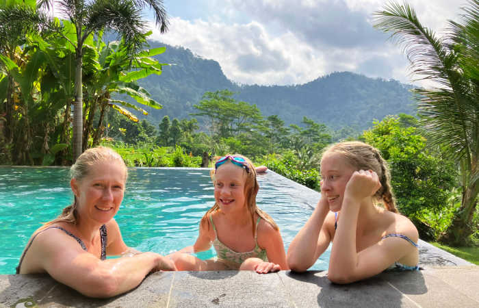 Family enjoying a pool in Bali, surrounded by rainforest