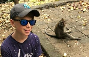 Child posing with monkey on