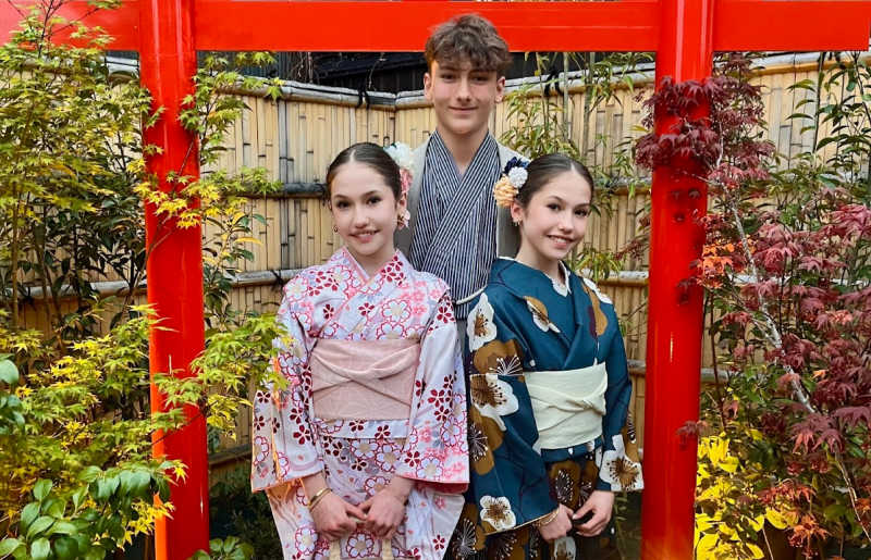 Brother and two sisters learning about traditional dress in Japan on family holiday