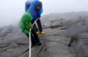Dad and son holding rope - climbing Mount Kinabalu with kids