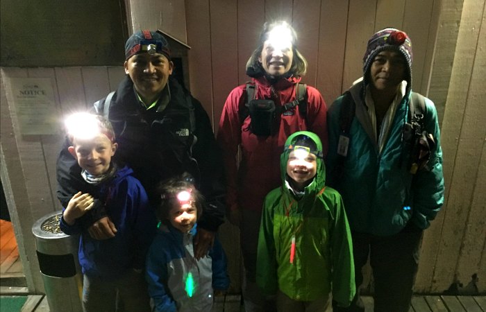 Family preparing for climbing Mount Kinabalu dressed in warm gear and head torches