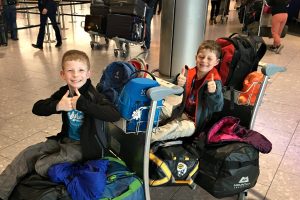 Kids at airport with luggage - ultimate family packing checklist blog