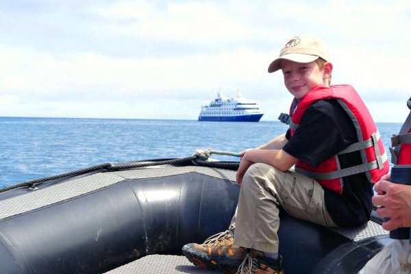 Galapagos Island cruise - young boy on a panga transferring from ship to land