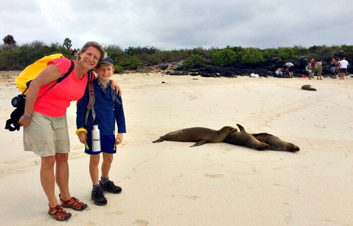Galapagos with kids - mother and son on the beach with sea lions