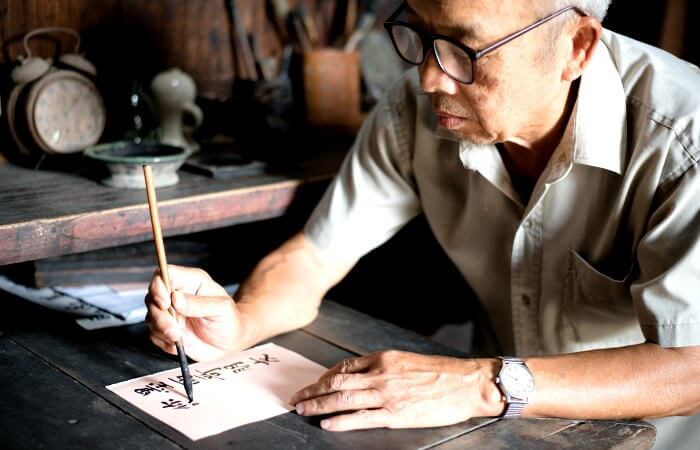Man demonstrating traditional Chinese calligraphy