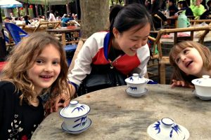 Two young girls taking afternoon tea on a China with kids itinerary