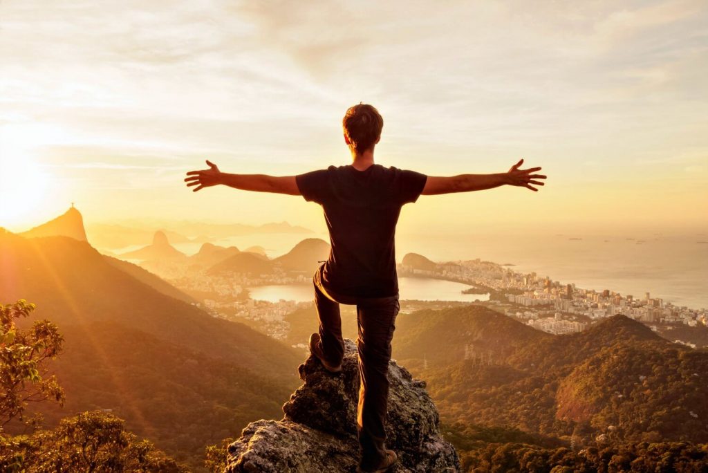 Family holidays in Brazil with Stubborn Mule Travel - teenager with arms spread, overlooking the classic view of Rio at sunset