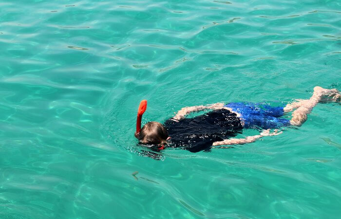 Snorkelling in emerald green water on Oman with kids itinerary