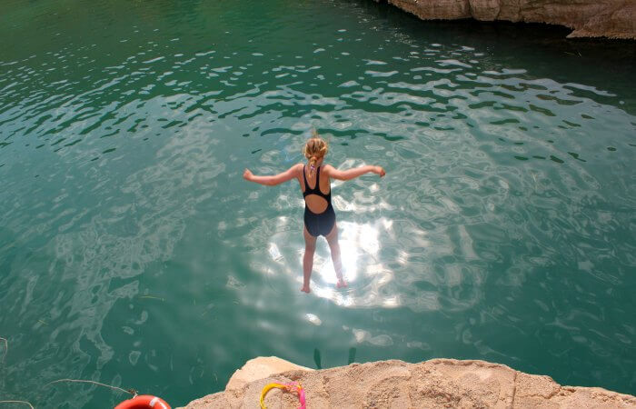 Jumping into pool at Wadi Bani Khalid - holidaying in Oman with kids