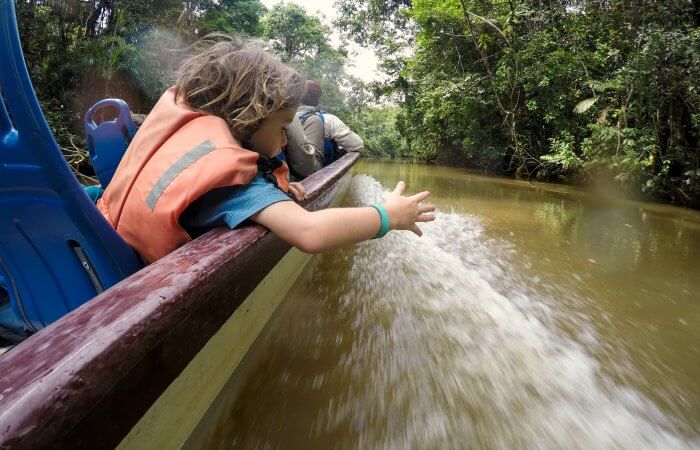 Child in boat exploring the Amazon - family wildlife holidays, Ecuador with kids