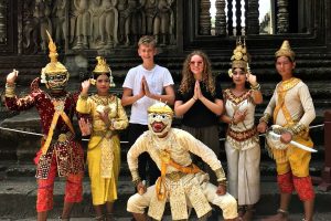 Cambodia with kids masthead - young visitors posing with dancers at Angkor Wat