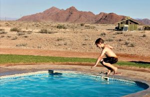 Namiia for kids - child jumping into a pool set in desert landscape