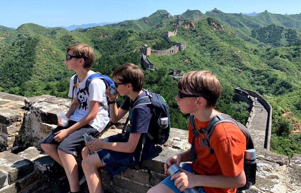 Family on adventure holiday sitting on the Great Wall of China