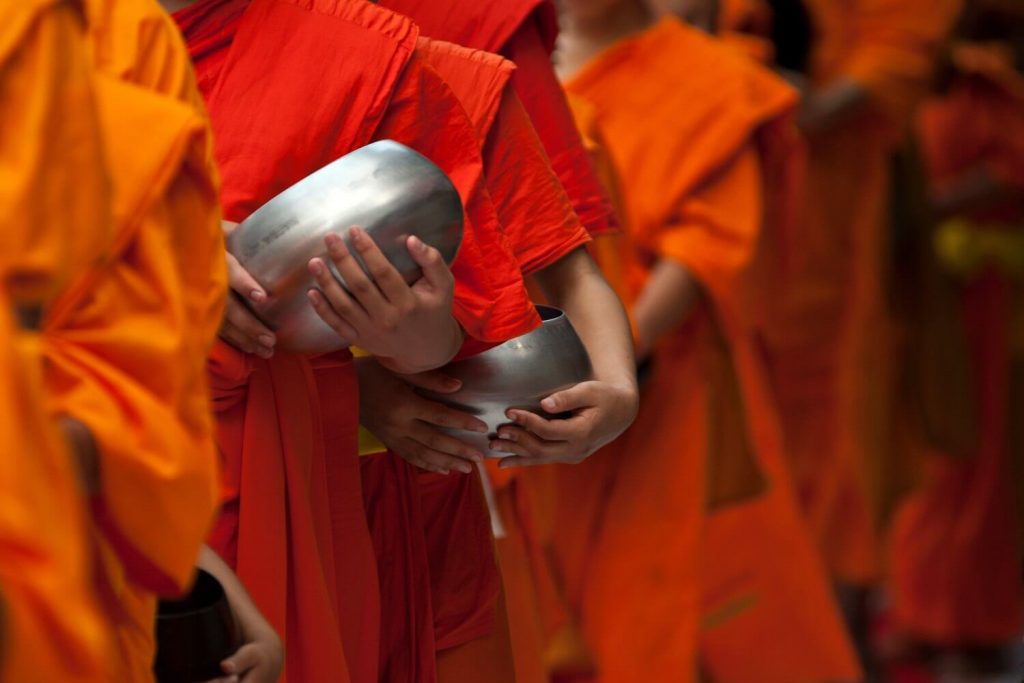 Laos family holidays masthead - close up of monks with alms baskets