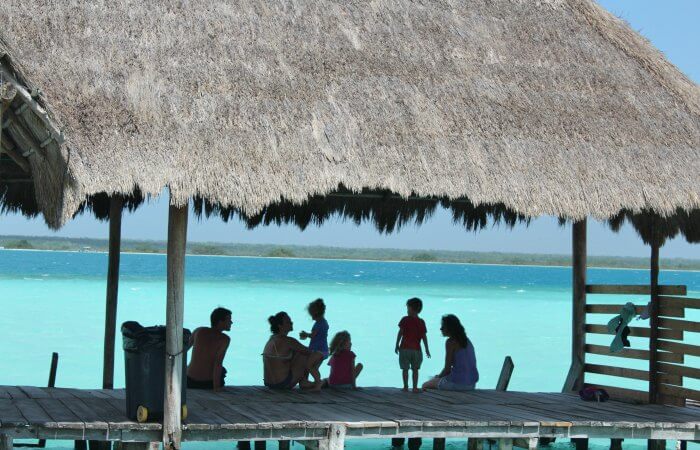 Families on jetty at Mexico's Lake Bacalar on adventure family holiday