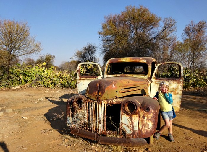 Young tourist standing next to old rusty truck in Namibia
