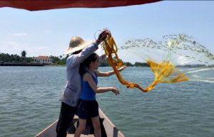 Youngster casting fishing nets in Vietnam on family Easter holiday