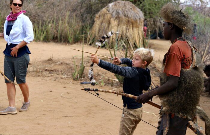 Learning to use a traditional bow and arrow on holiday in Tanzania with the children