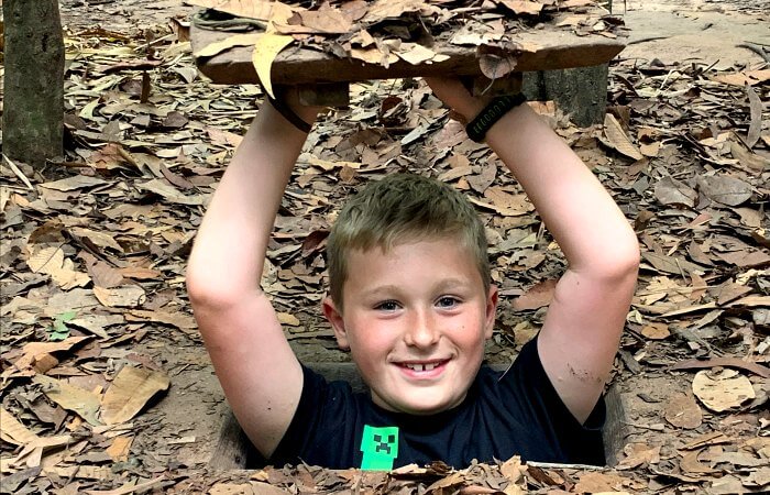Travel trends 2020 - young boy exploring the Chu Chi Tunnels in Vietnam