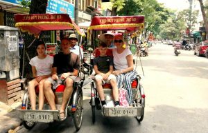 Family on cyclo tour of Hanoi on Vietnam with children holiday