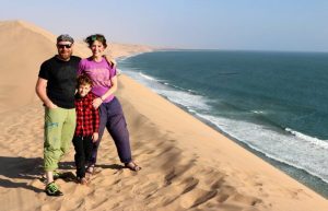 Parents and child in desert scenery by the coast - Family travel 2020