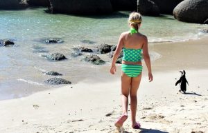 Child with penguin on Boulders Beach - South Africa with kids itinerary