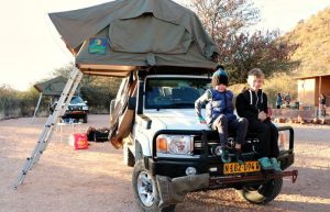 Kids sitting on car bonnet - Namibia family road trip