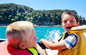 Kids enjoying a boat trip in the Abel Tasman National Park on a New Zealand Family holiday