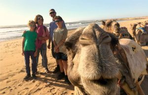 Family with camels on Morocco beach - half term holiday destination