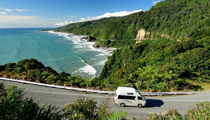 Where to stay in New Zealand - a camper van in gorgeous coastal scenery