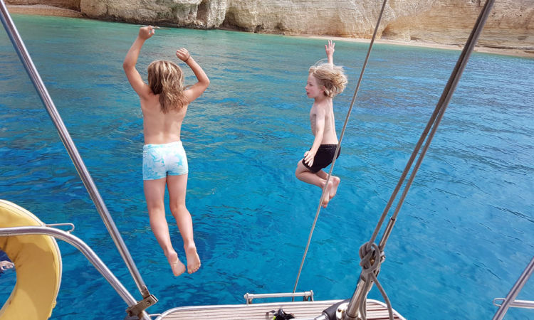 Kids jumping off a boat in the Med - Greece family holidays