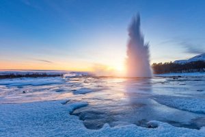Iceland in winter itinerary - geyser blowing at sunset