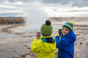 Family holidays in Iceland - Children enjoying the eruption of Strokkur Geysir in Iceland
