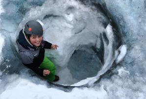 Girl exploring Iceland in winter - ice cave