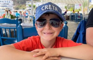 Boy smiling in Crete baseball cap