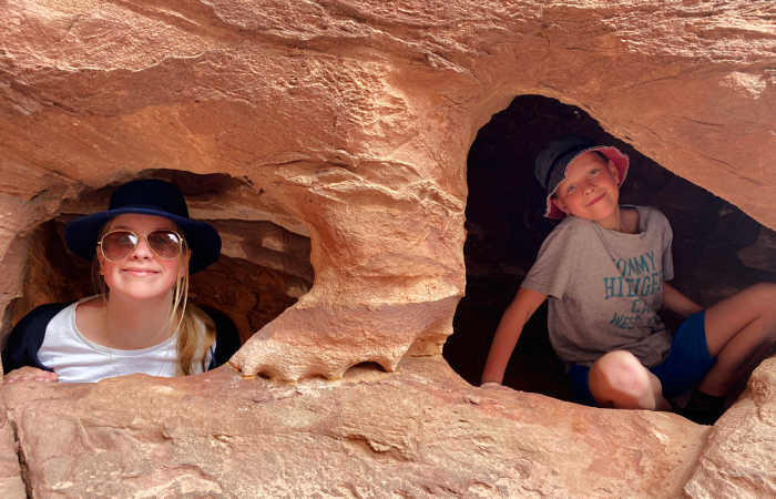 Teenager and brother exploring Little Petra Caves, Jordan holiday with kids