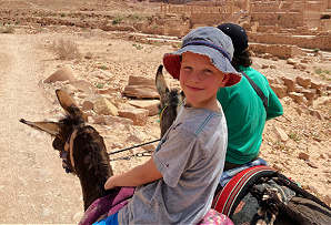 Highlights of Jordan itinerary - young boy riding donkey to Petra