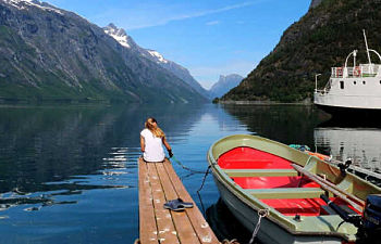 Girl on fjord dock, visiting Norway in Summer school holiday