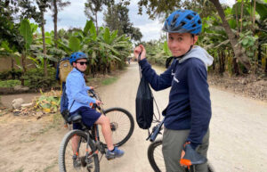 Family cycling in Tanzania through banana plantation