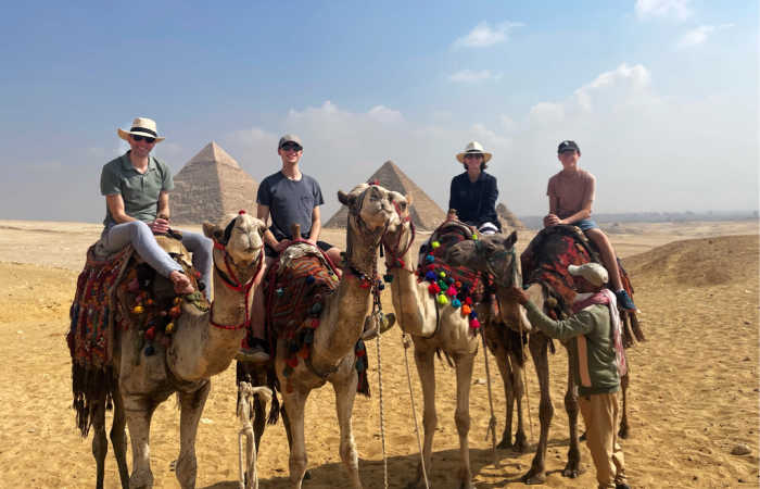 Family riding camels at the Pyramids, Egypt with kids holiday