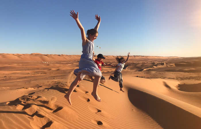 Family playing in dunes, Oman, October half term