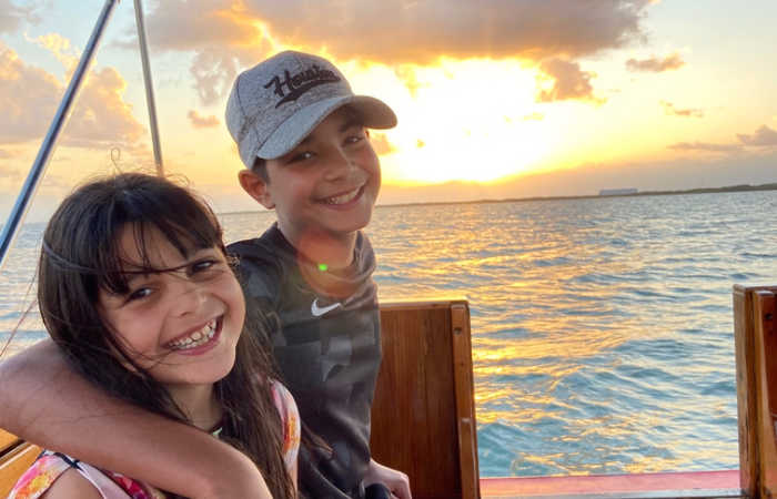 Brother and sister smiling on boat trip in Placentia, on Belize with kids holiday.
